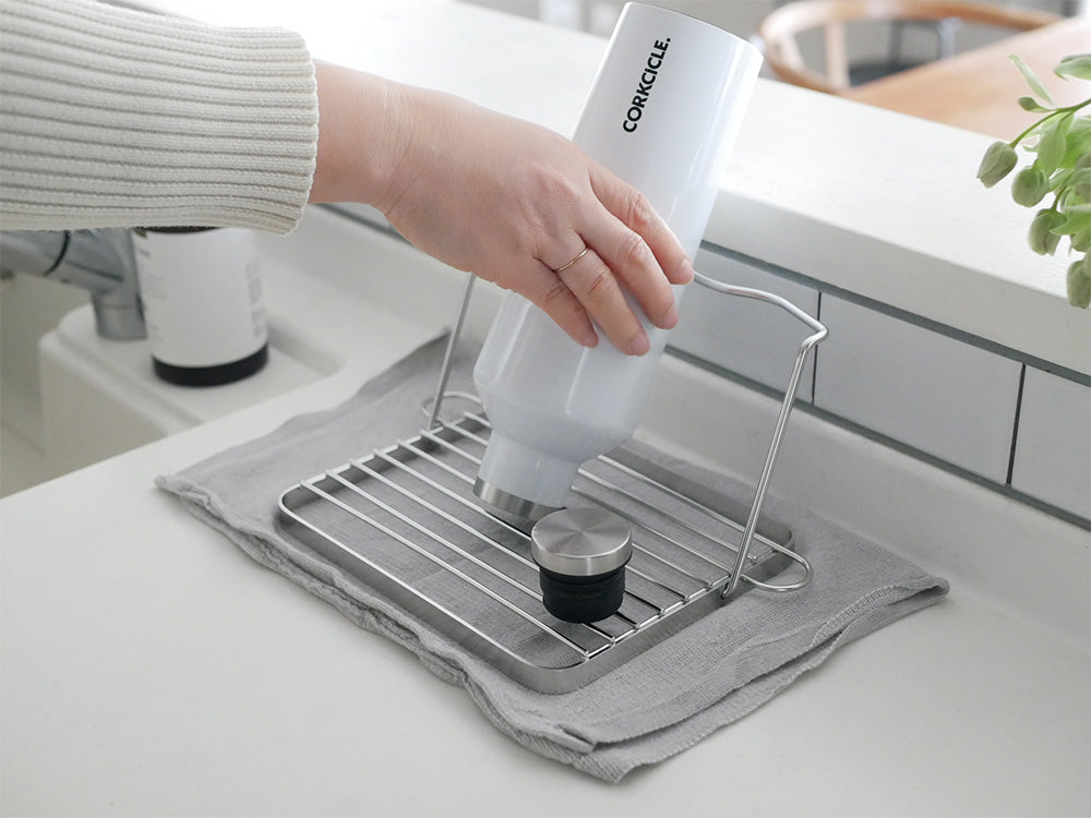 bws SELECTIONの折りたためるジャグボトルスタンドがキッチンカウンター上でボトルを支えている様子