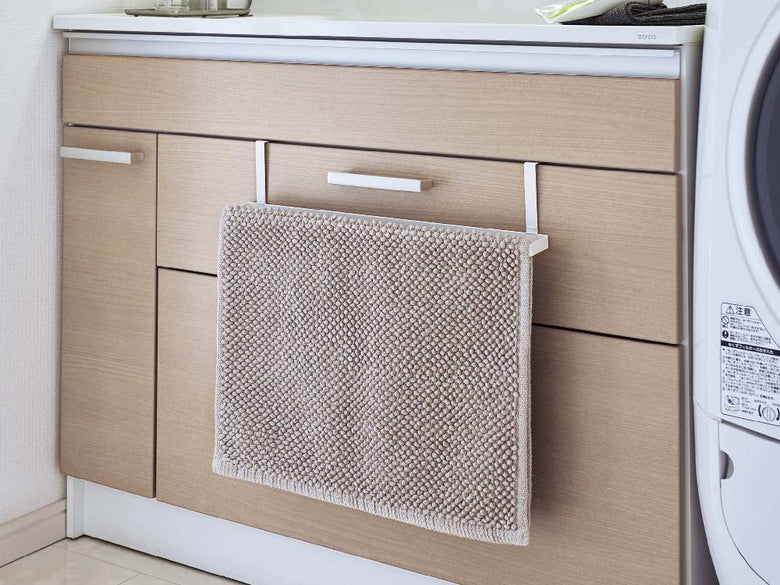 洗面下のキャビネットにスチール製バスマットとタオルハンガー「PLATE/プレート」が掛けられている様子