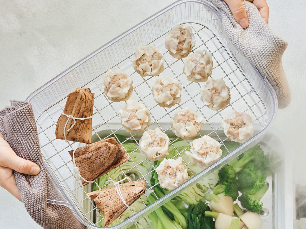 ホットプレート上で丸洗い可能なコンパクトクリアスチーマーを使用して野菜を蒸している様子