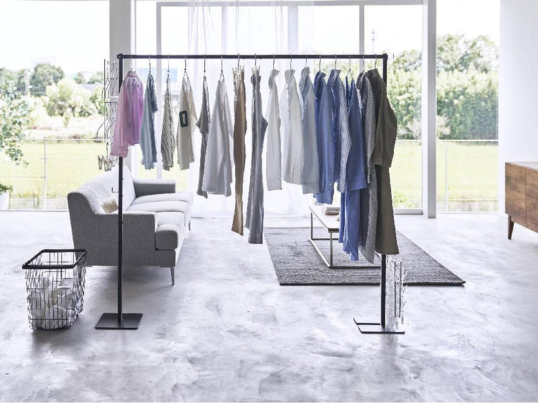 タワー折り畳み室内物干しのスチール製ハンガーラックが室内に設置され、インテリアに調和するデザインの様子