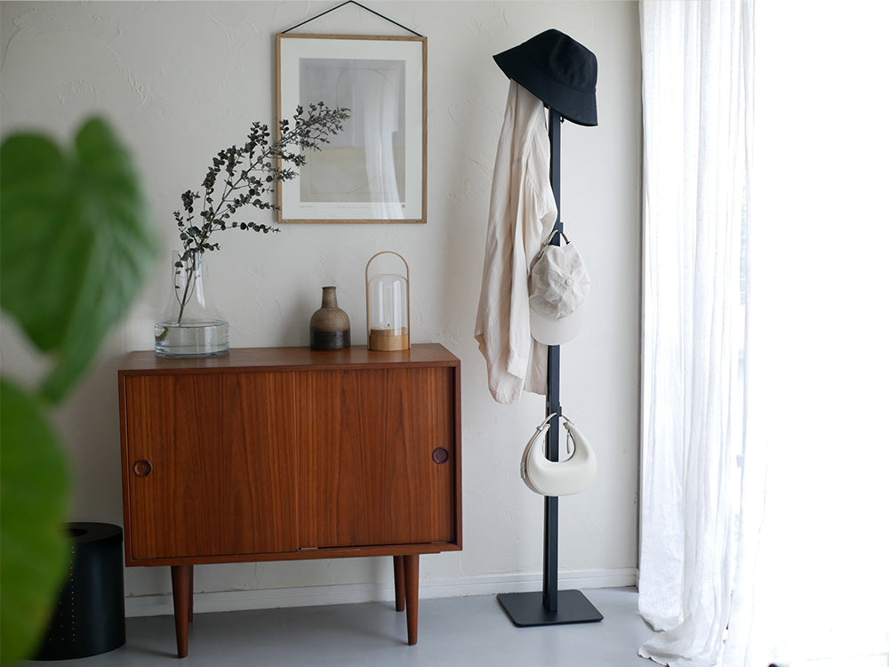 家具や観葉植物と調和した室内インテリアに配置されたスチール製の折り畳み式タワー物干し