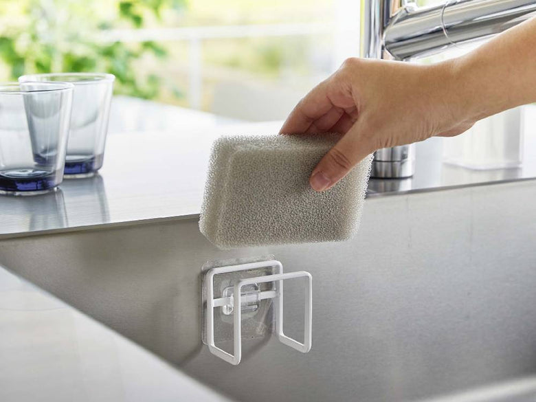 タワーのフィルムフックスポンジホルダーが取り付けられたキッチンシンクセット。蛇口、スポンジ、ソープディスペンサーなどのキッチン用品が整然と配置されています。