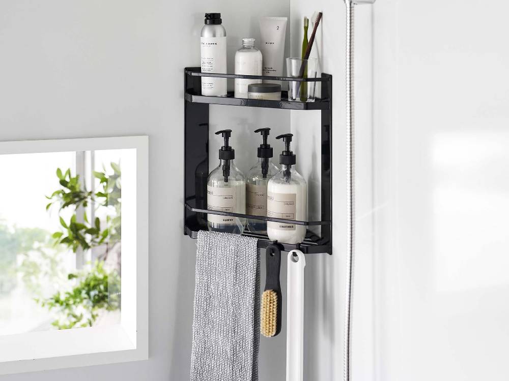 浴室のコーナーに設置された【tower/タワー】マグネットバスルームコーナーラック2段。スチール製でボトルや洗面用品が整然と収納されています。