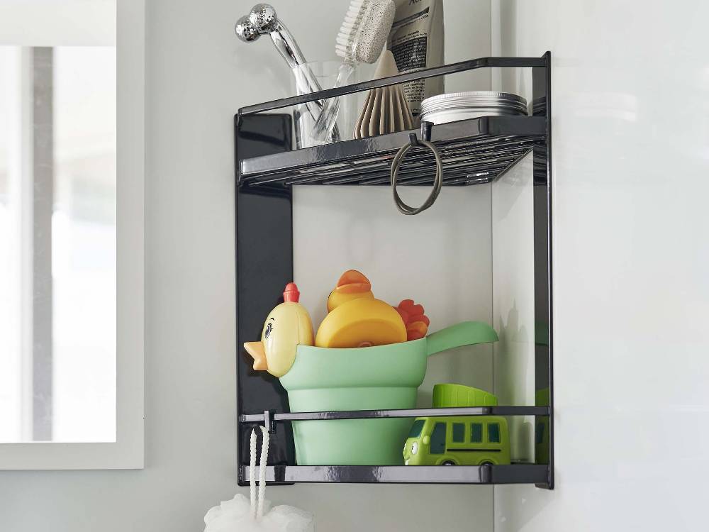 スチール製マグネット2段タワーラックが浴室のコーナーに設置され、ボトルや食器ラック、キッチン用品を整理している様子