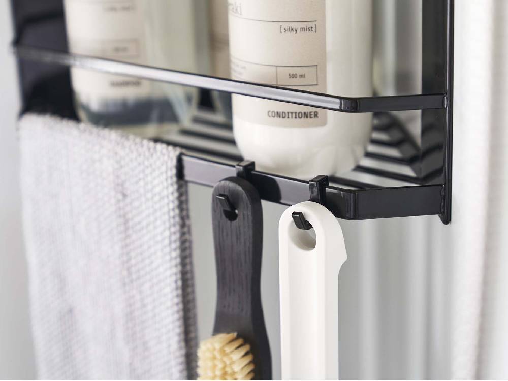 シルバー製の2段マグネットバスルームコーナーラックにタオルや衣類が掛けられている様子