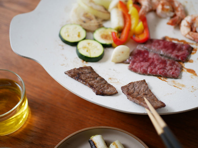 卓上IHクッキンググリドルの上で牛肉と野菜を調理している様子が写った写真