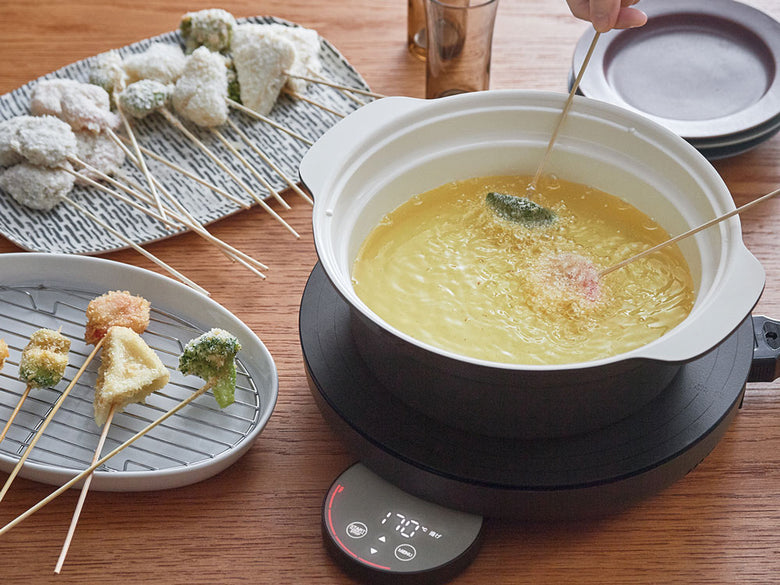 レコルトの卓上IHクッキンググリドルと付属の鍋や調理器具がキッチンカウンターに整然と配置されている様子