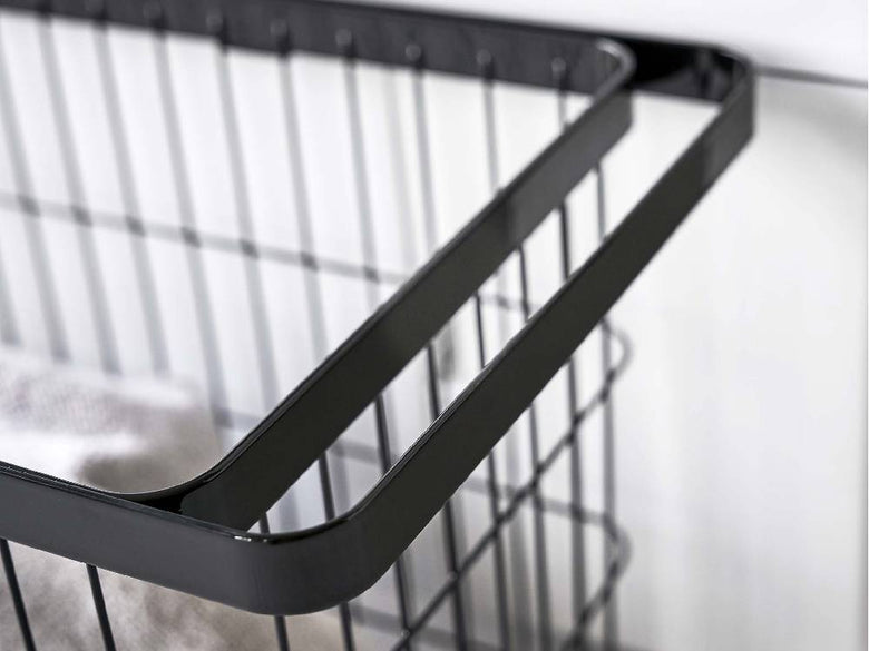 スチール製キャスター付きワイド＆ローランドリーバスケットが棚に収納されている様子