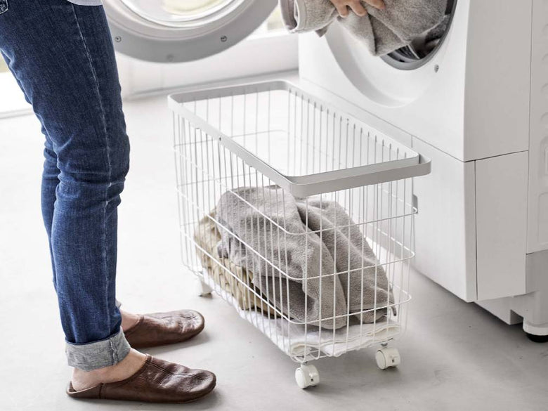 キャスター付きスチール製ワイド＆ローランドリーバスケットが洗濯室に置かれている様子