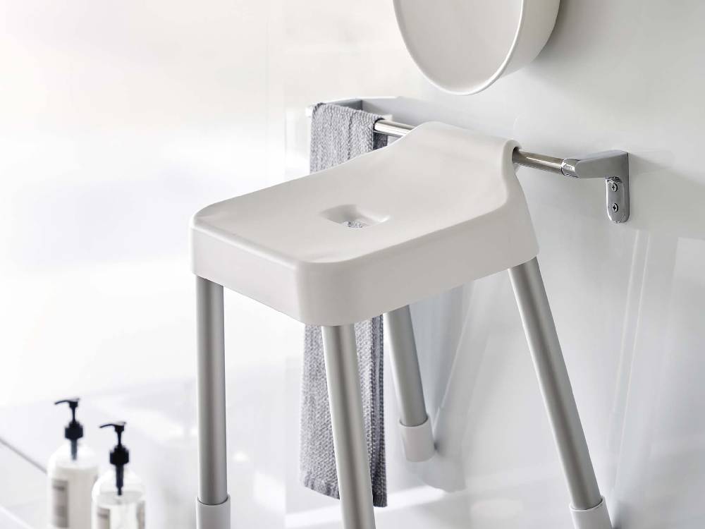 白色の引っ掛け風呂イス SH35がアルミ合金のパイプに掛けられた浴室の様子