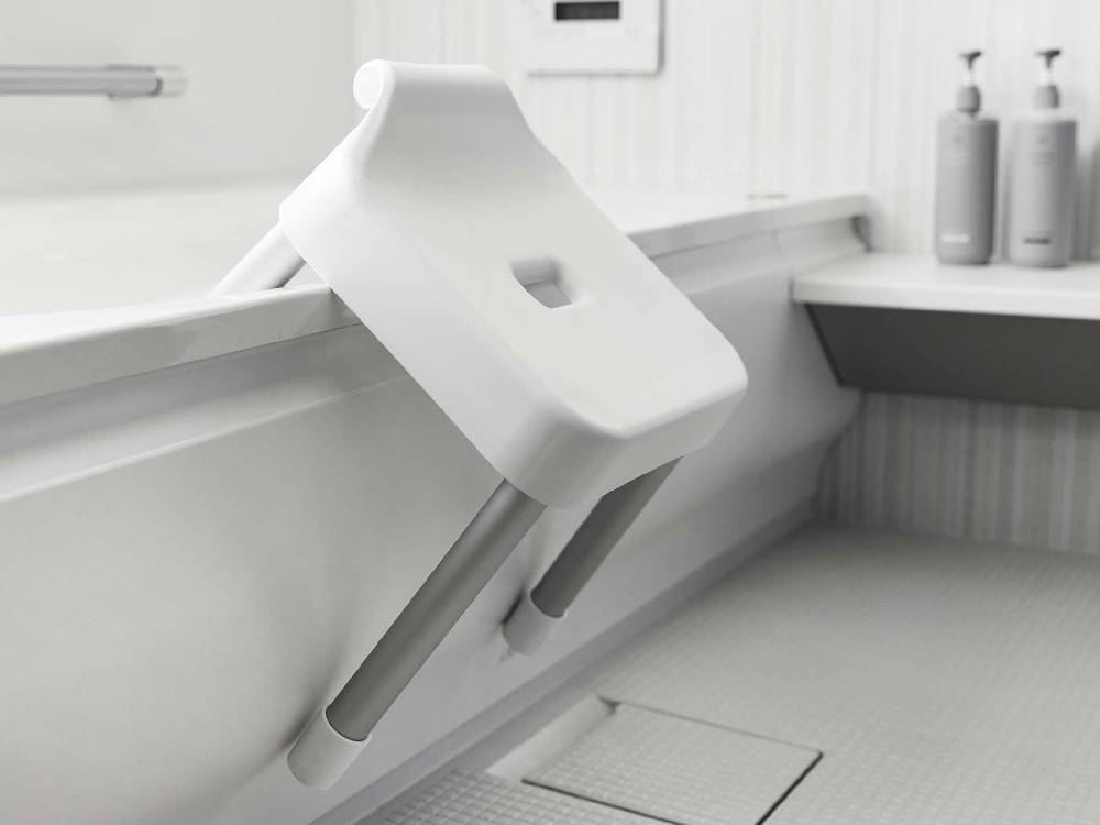 浴室の浴槽に掛けられた【MIST/ミスト】引っ掛け風呂イス SH30。銀色のアルミニウム合金パイプとプラスチック製座面を備えた耐荷重100kgのバスルーム用椅子