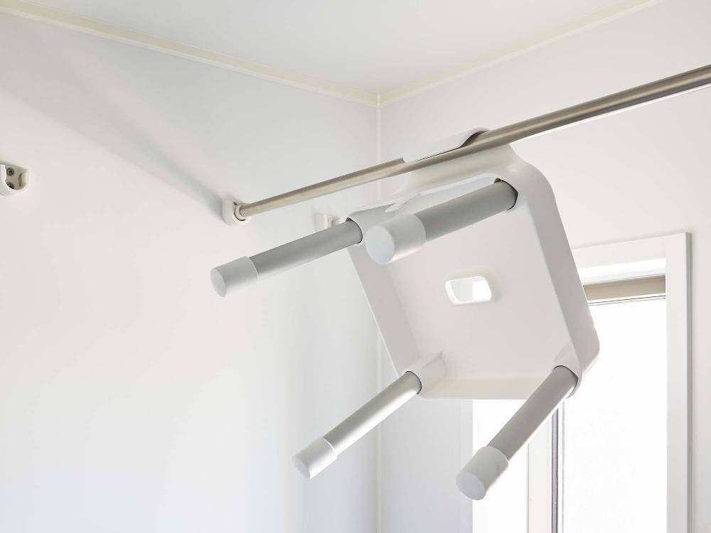 天井に取り付けられた銀色のアルミニウム合金製パイプに接続された引っ掛け風呂イス SH25用フック