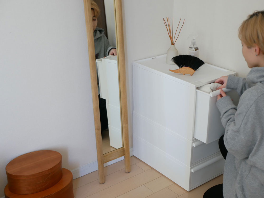 チーク無垢材と合板で作られた全身映るスリムミラー「HOKOS」が木製フロアとキャビネットの上に配置されているインテリアの様子