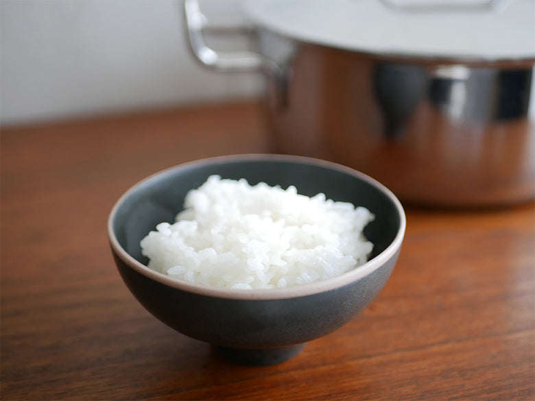 白ご飯が盛られたボウルと18-8ステンレス製の蓋付き鍋がキッチンテーブルに並ぶ様子