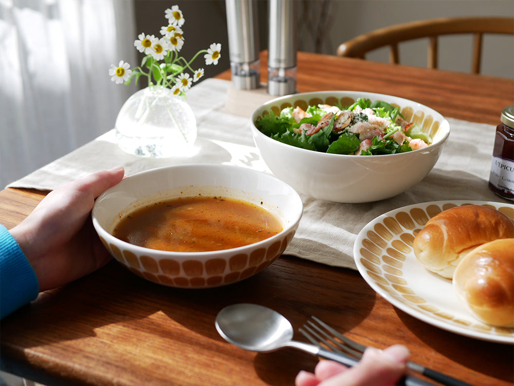 アラビア製磁器の24hトゥオキオボウルがテーブルウェアや料理とともにテーブルに美しく配置されている様子