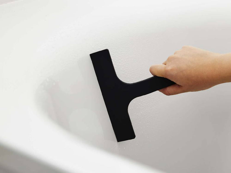 白色のマグネット水切りワイパーがスチール壁に取り付けられている様子