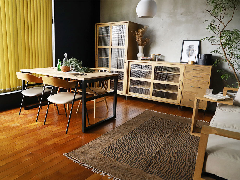 アデペシュのコットンラグが木製フローリングに敷かれ、テーブルと椅子が配置されたスタイリッシュな室内デザイン