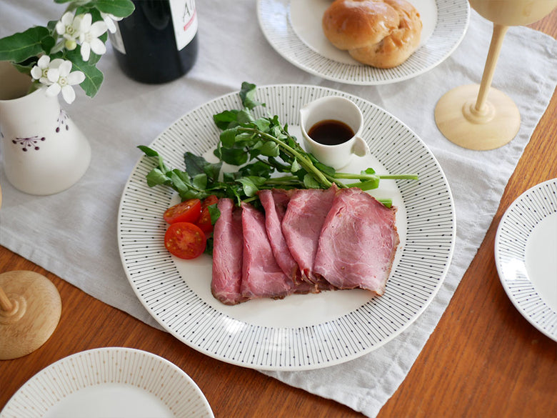 アラビアマイニオ磁器製プレートがテーブルクロスの上に美しく並べられている様子