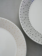 アラビア製マイニオプレートのディナーウェアセット。15cm、19cm、25cmの白磁プレートが整然と並んでいる