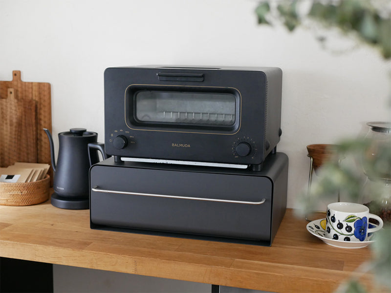 キッチンカウンターに設置された【UtaU】カウンタードロワーのピュアホワイトモデル。開いた引き出しにはトースターや小型家電が整理整頓されている様子を示しています