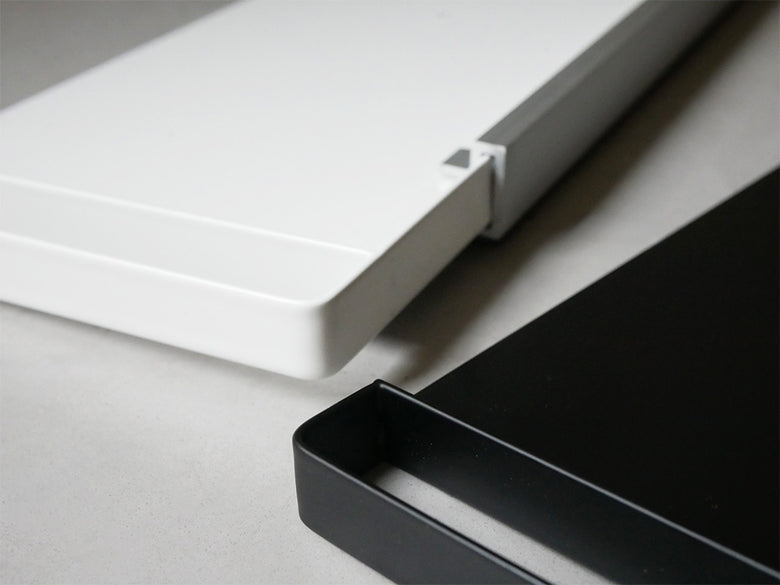 銀色のマグネット式スライドスチールパネルが冷蔵庫横に取り付けられ、収納スペースとして利用されている様子。