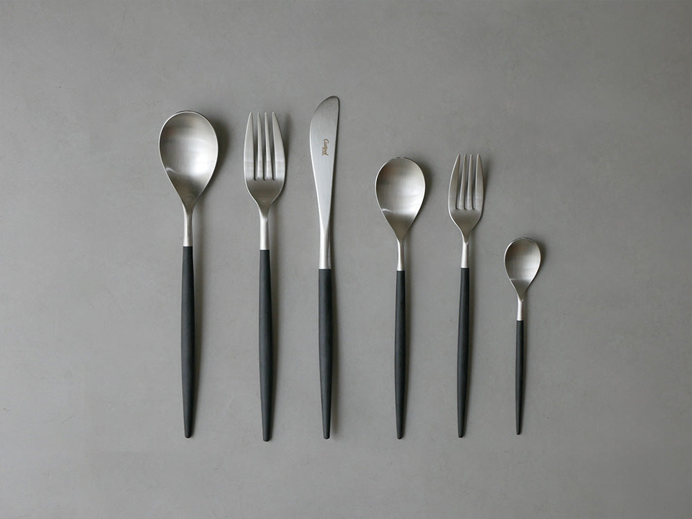 クチポールのMIO ブラックシルバー カトラリーセット、ディナーフォークとスプーンが並んだキッチン用品の写真