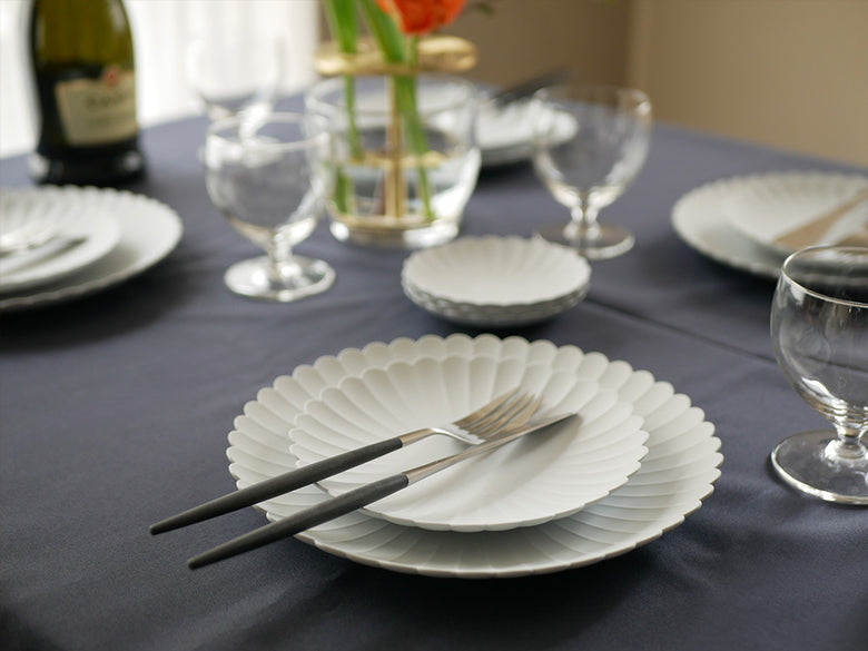 MIO カトラリーのフォーク、スプーン、ナイフがテーブルクロスの上に整然と配置されたディナーセット