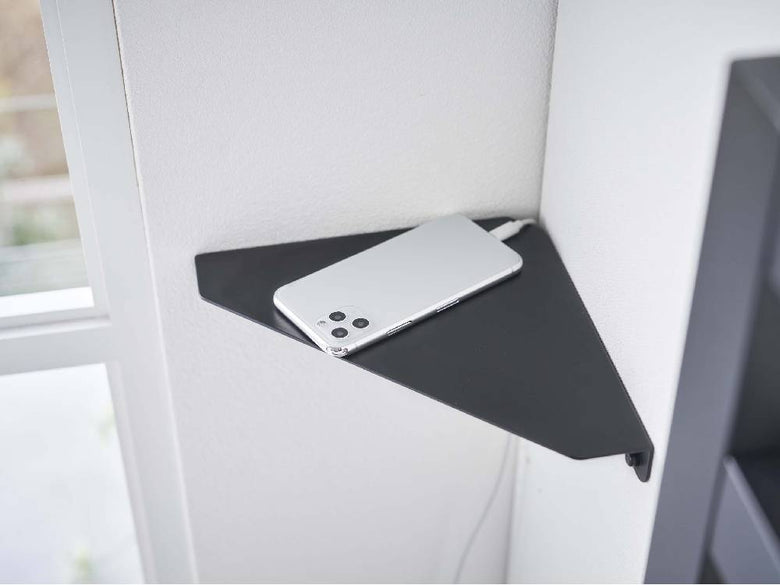 スチール製タワー型コーナーシェルフが石こうボードの壁に設置されている様子