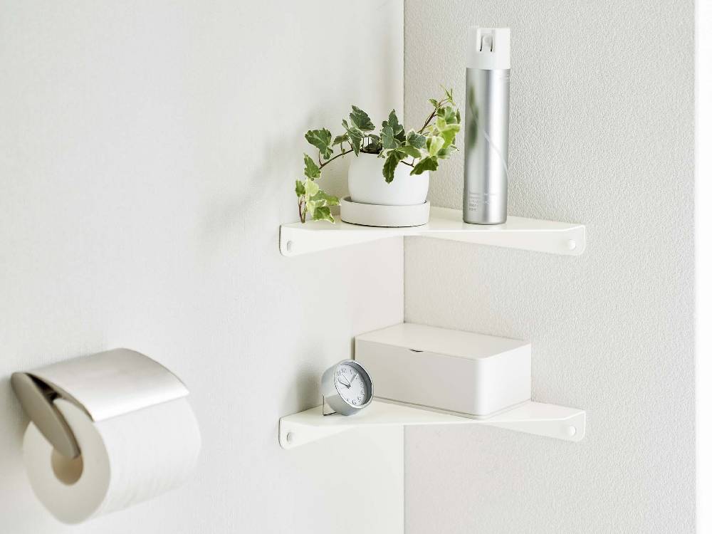 スチール製タワー型コーナーシェルフにトイレットペーパーやペーパータオルが整然と収納されている様子