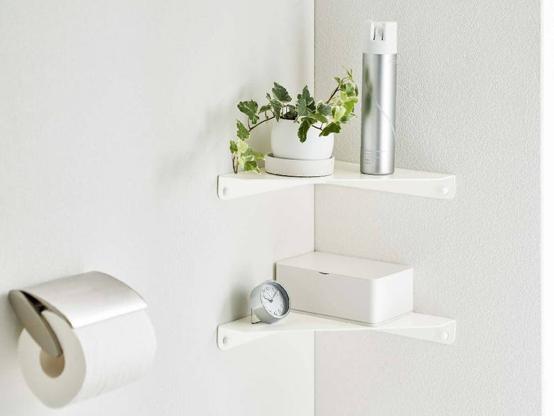 スチール製タワー型コーナーシェルフにトイレットペーパーやペーパータオルが整然と収納されている様子