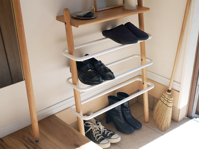 オーク無垢材とスチール製の壁掛けシューズラックに、複数のサンダルが整然と並べられている様子