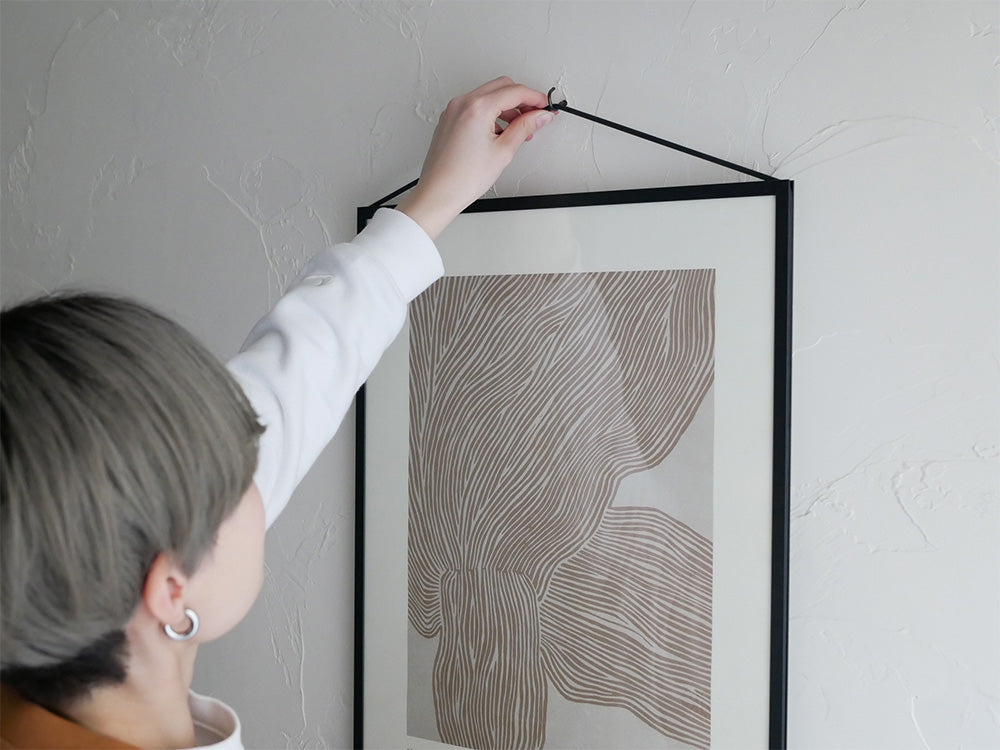 モダンデザインのグレーカラーMOEBEフレームが配置された静物写真。オーク材およびアルミニウムブラックモデルあり。