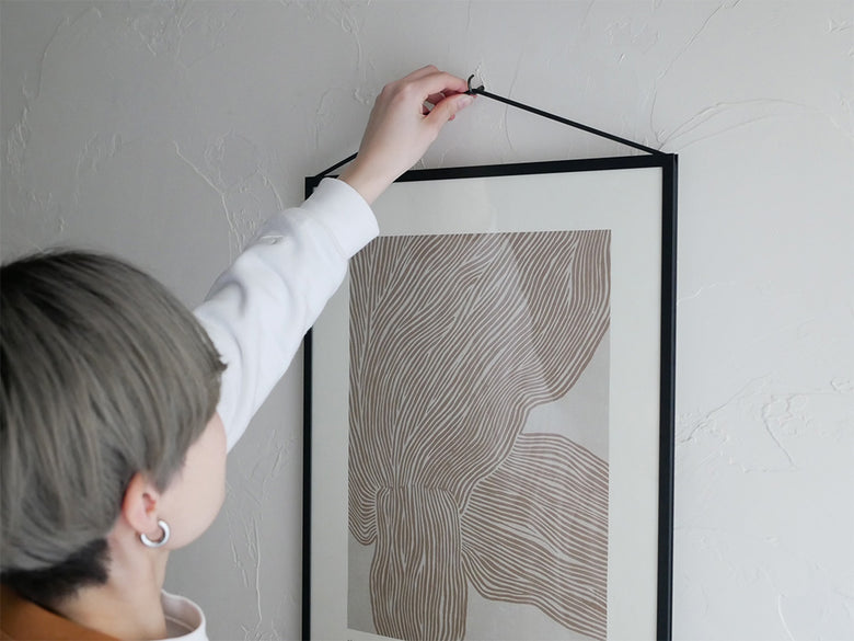 モダンデザインのグレーカラーMOEBEフレームが配置された静物写真。オーク材およびアルミニウムブラックモデルあり。