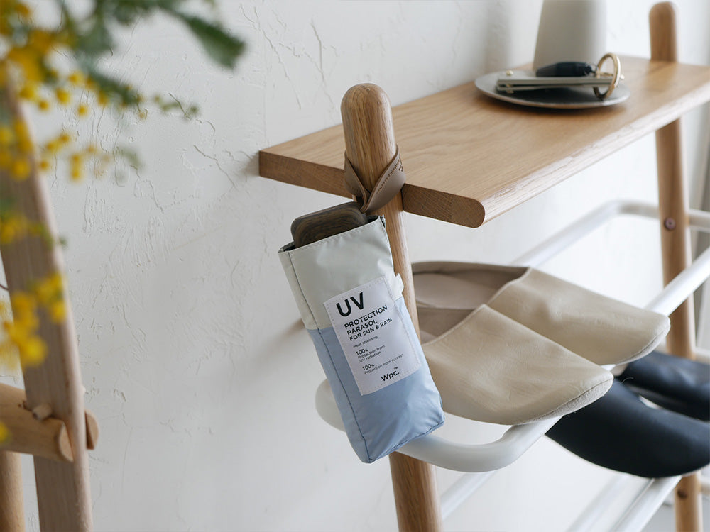 木製家具の上に置かれたポリエステル生地のスマホサイズ折りたたみ傘