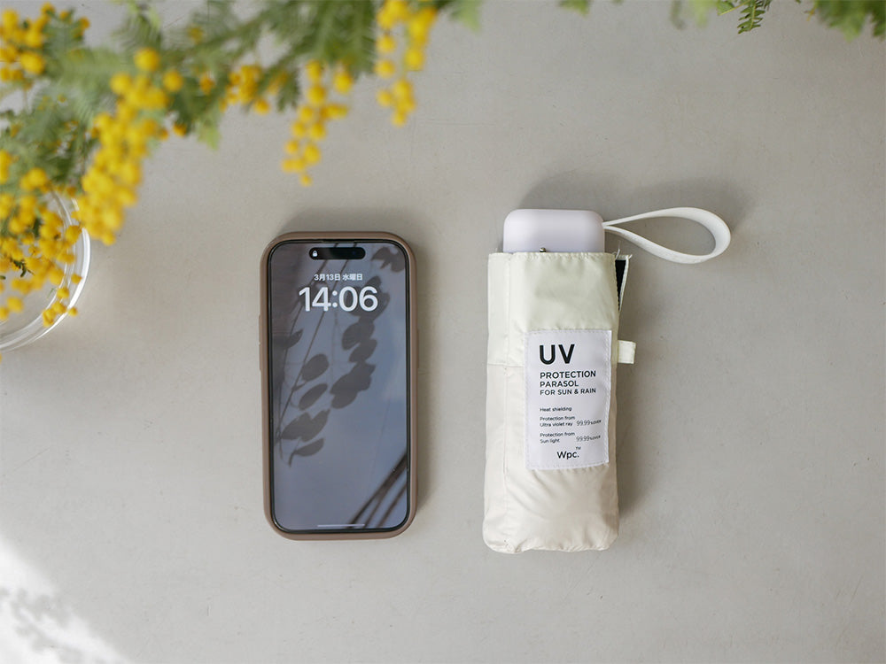 Wpc.ダブリュピーシーのスマホサイズ折りたたみ傘。黒色のポリエステル生地で完全遮光・UVカット機能を備え、軽量210gでコンパクトに収納可能な携帯用デザイン。