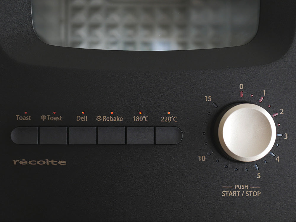 クリームホワイトのレコルトスライドラックトースター本体とスライドラック、トレイなどの付属品が整然と配置されたキッチン家電の画像