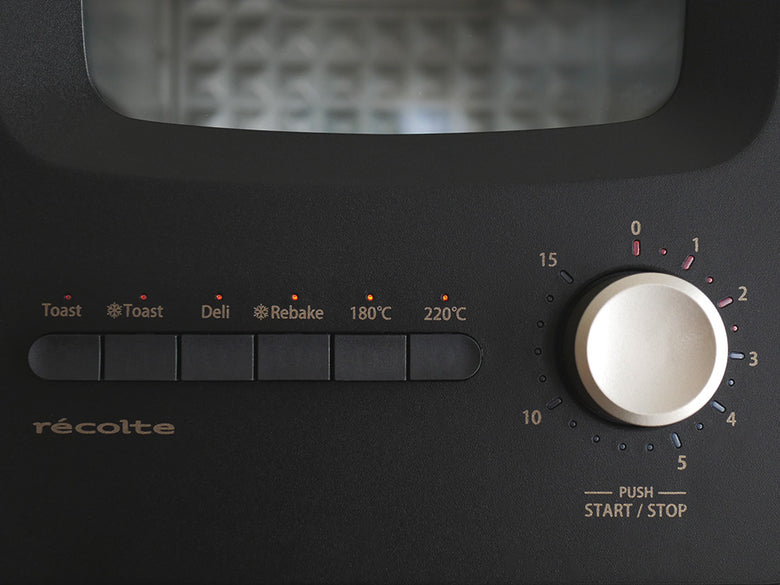 クリームホワイトのレコルトスライドラックトースター本体とスライドラック、トレイなどの付属品が整然と配置されたキッチン家電の画像