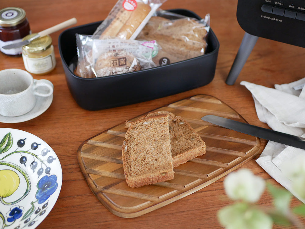 クリームホワイトのレコルトブレッドケースにライ麦パンと全粒粉パンが収納されているキッチン用品の写真
