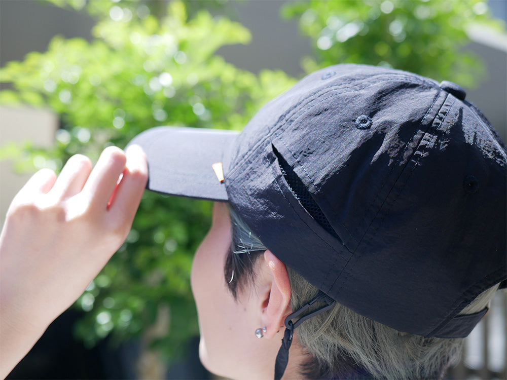 インプルーブの撥水機能付きパラソルチャームブラックキャップ。バケットハットスタイルでサイズ調整可能、通気用メッシュ付き