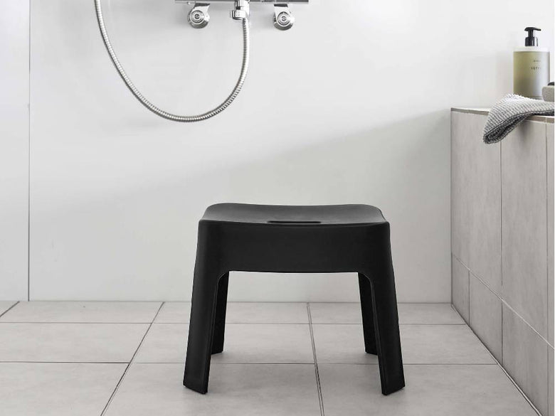 銀色のプラスチック製マグネット風呂イス SH25が浴室の平らな壁面に取り付けられている様子