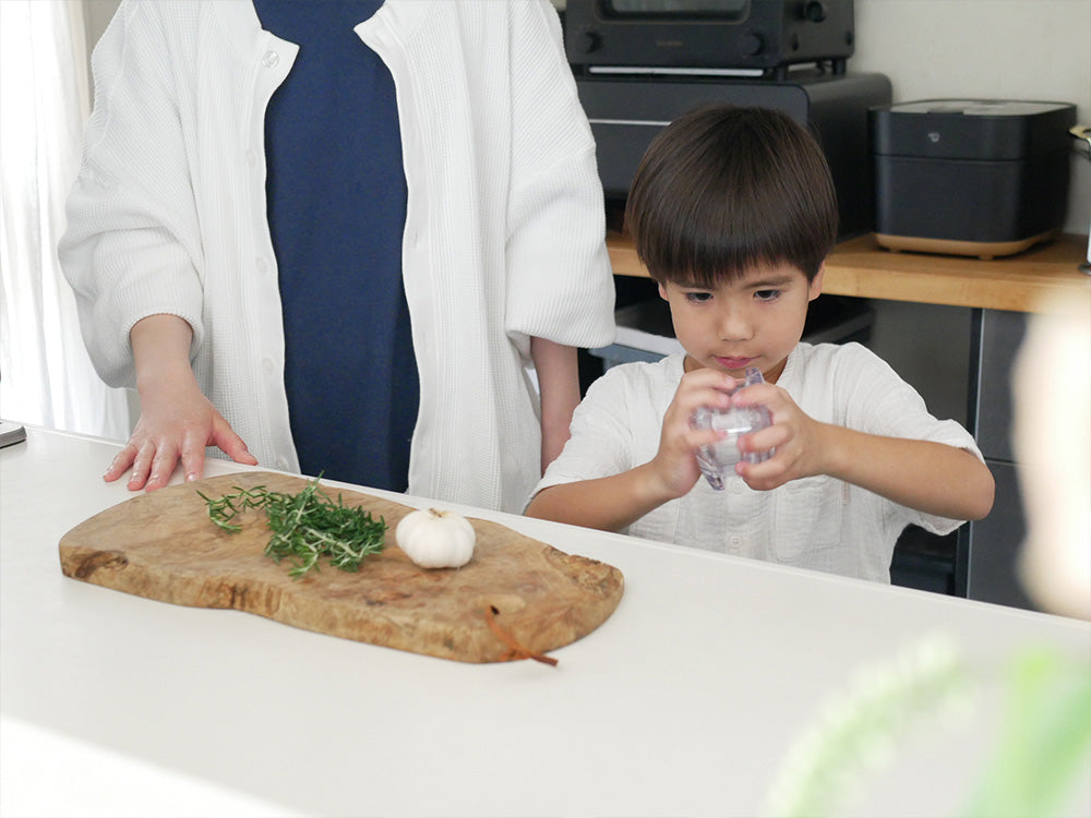 アークトレーディングのガーリックツイストを使って子供と大人が野菜を調理している様子
