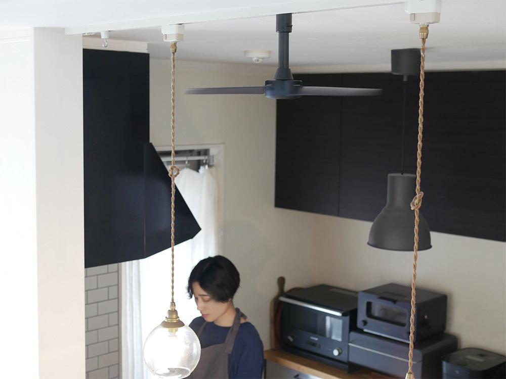 ダクトレールファンDCベーシックΦ40を装備した天井の照明器具。シャンデリアと電気ケーブルが見えるモダンなインテリアデザイン