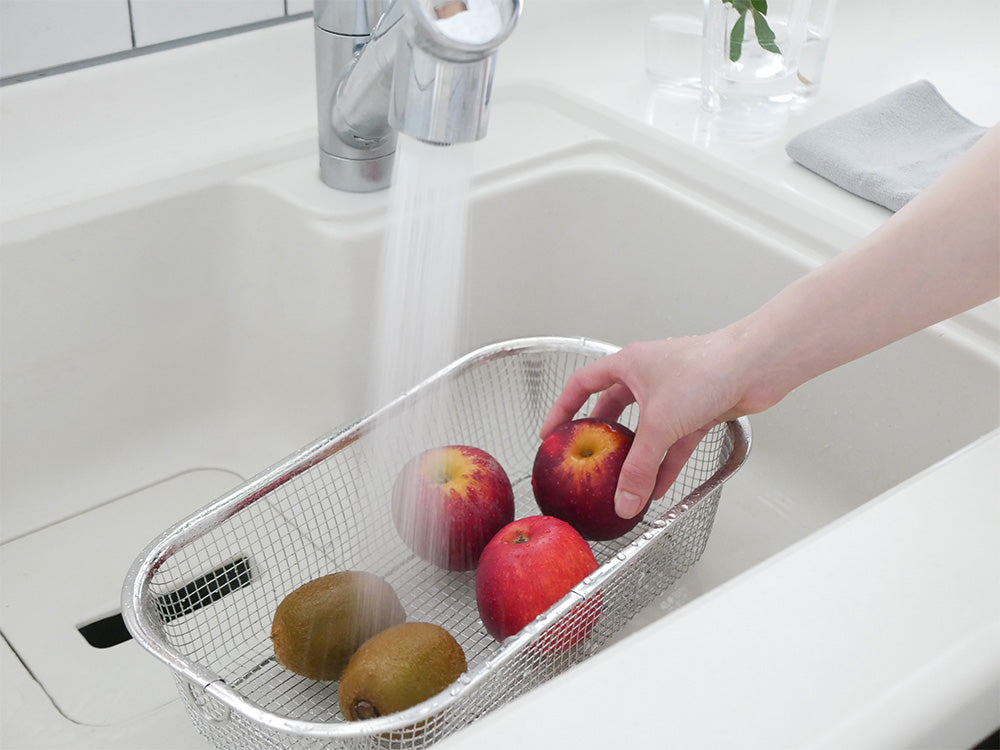 キッチンシンクに設置された18-8ステンレス製のすっきり暮らす水切りかごと蛇口、バスケットが見える