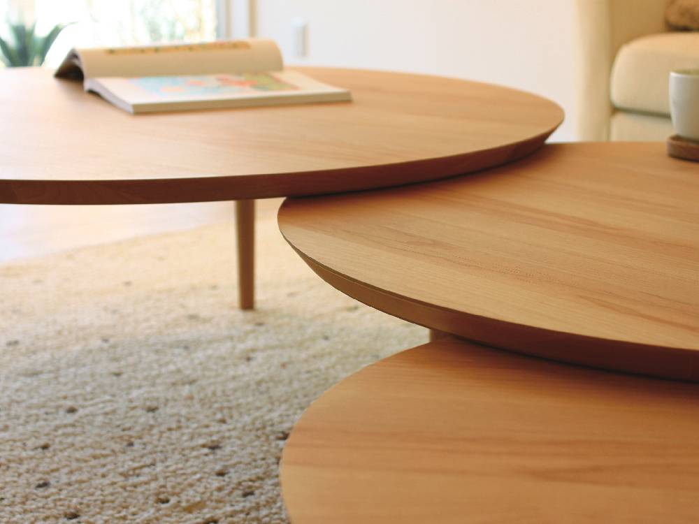 高野木工のBALLOONシリーズ、伸縮可能なホワイトオークまたはウォルナット製の木製リビングテーブルがリビングルームに配置されている様子