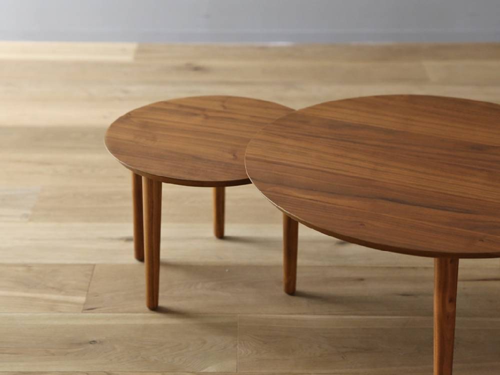 高野木工のBALLOONシリーズ、ホワイトオークまたはウォルナット材を使用したブラウン色の伸縮可能なリビングコーヒーテーブルに花束が飾られています。