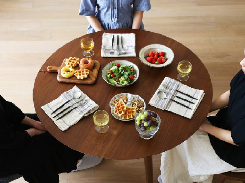 高野木工のMALLOONダイニングテーブルに食器やサラダ、飲み物が美しくセッティングされた食事風景