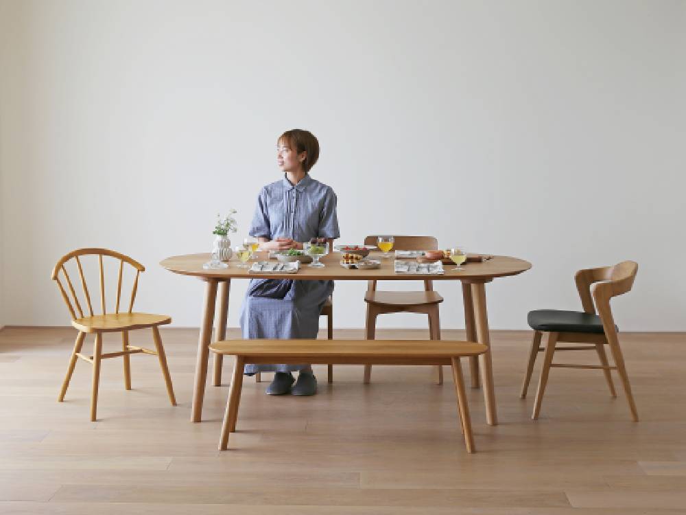高野木工のホワイトオーク製RUBEダイニングテーブルと椅子が配置され、木材の質感と植物が調和したダイニングルームの風景
