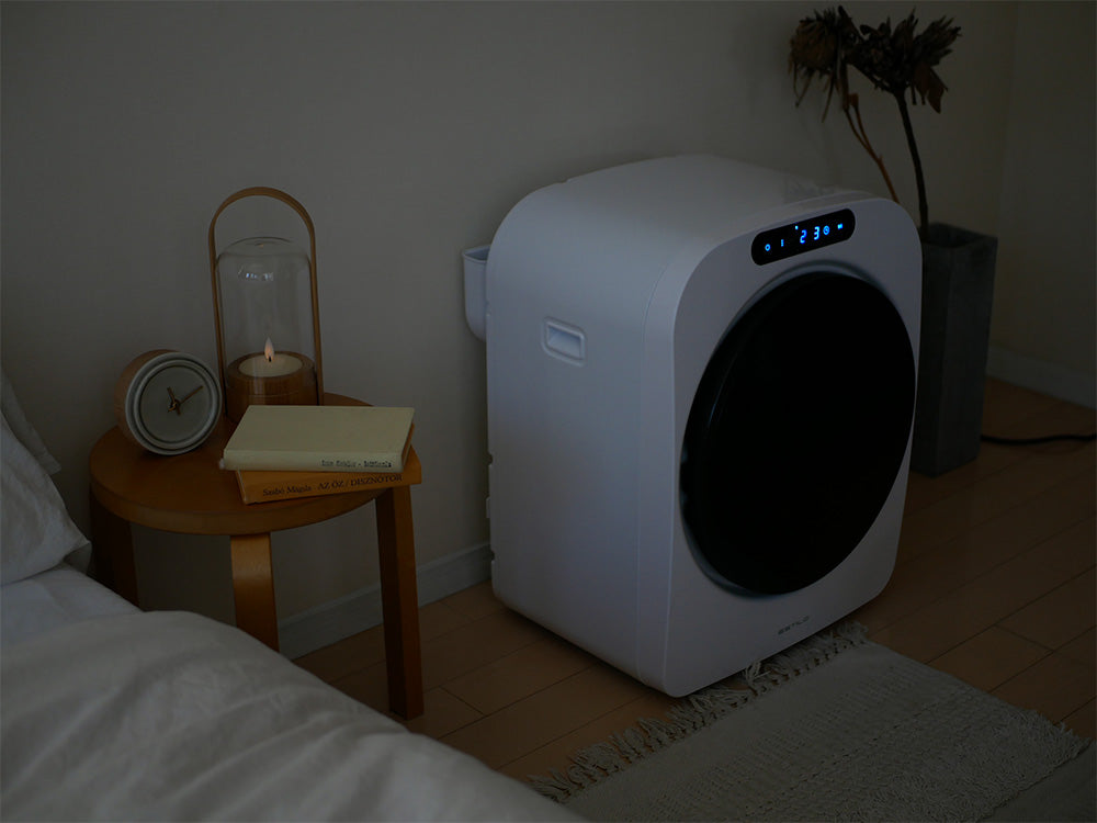 ESTILO（エスティロ）コンパクト衣類乾燥機の外観。シルバー色の本体が見え、コンパクトなデザインで家庭用に最適な電化製品です。