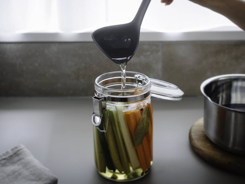 ナイロンとシリコーンゴム製の【marna/マーナ】マーナのきほん お玉が食材や調理器具と共にキッチンに置かれている様子