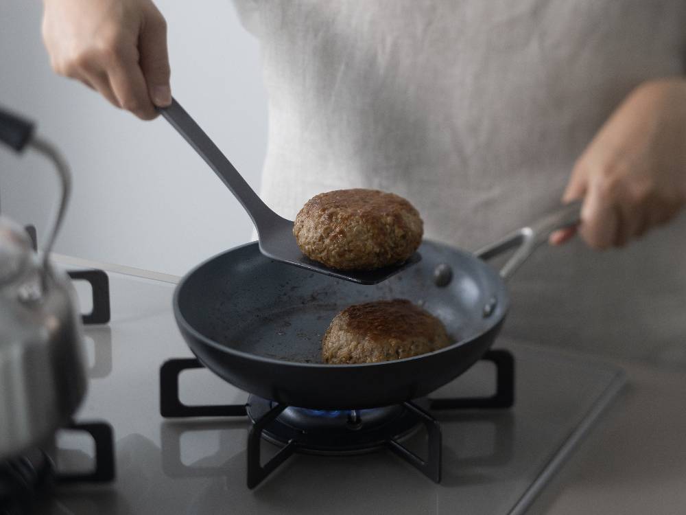 マーナのシリコーンターナーをフライパンで使用して料理しているキッチン用品の写真